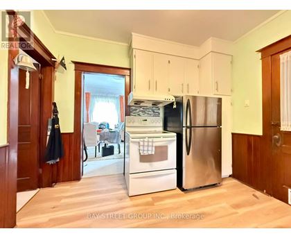 A kitchen with a refrigerator, oven, and sink.
