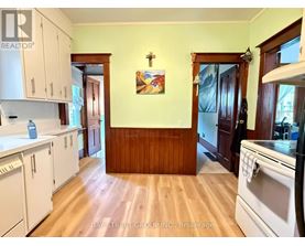 A kitchen with white cabinets and a wooden wall.