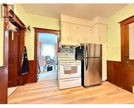 A kitchen with a refrigerator, oven, and sink.