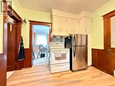A kitchen with a refrigerator, oven, and sink.