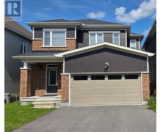 A two-story house with a garage door is for sale.