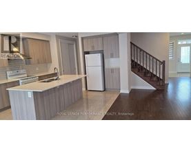 A kitchen with a refrigerator, sink, and stove.