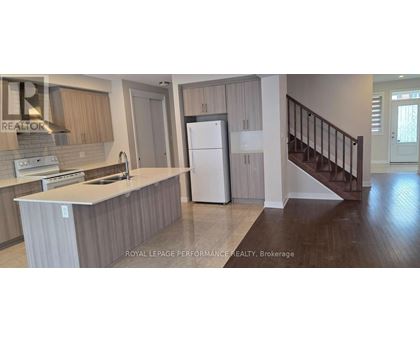 A kitchen with a refrigerator, sink, and stove.