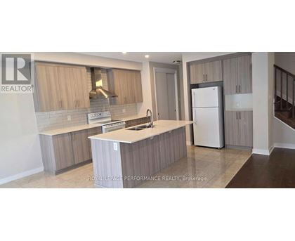 A kitchen with a white countertop and wooden cabinets.
