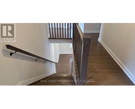 A wooden staircase with a metal railing.