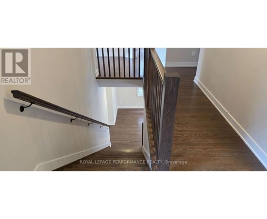 A wooden staircase with a metal railing.