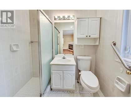 A white bathroom with a toilet, sink, and shower.