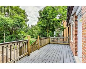 A wooden deck leads to a lush green backyard.