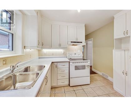A kitchen with white cabinets and appliances.