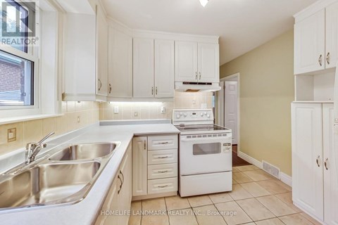 A kitchen with white cabinets and appliances.