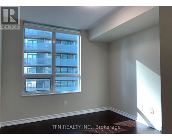A room with a large window and a view of a building across the street.