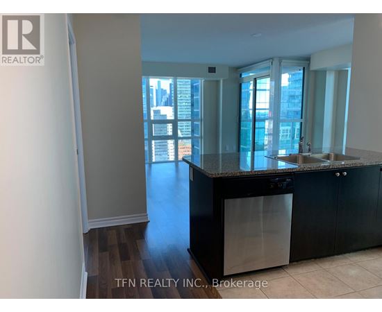 A kitchen with black cabinets and a dishwasher is shown.
