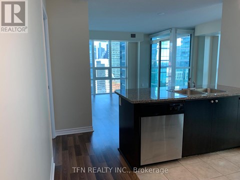 A kitchen with black cabinets and a dishwasher is shown.