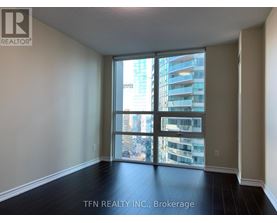 A room with a view of a cityscape through large windows.