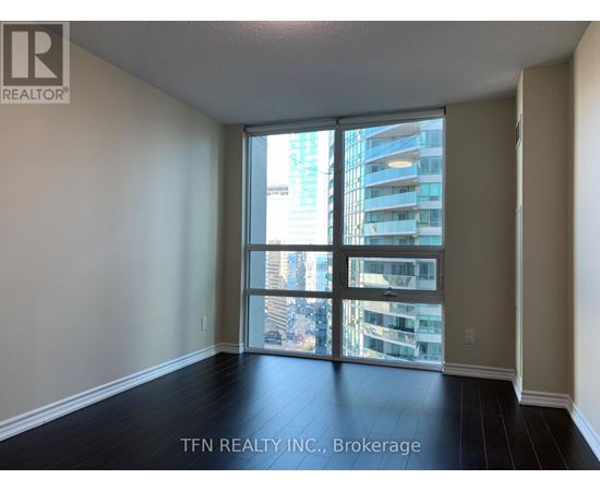 A room with a view of a cityscape through large windows.