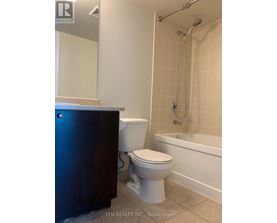 A white toilet sits next to a white sink in a bathroom.