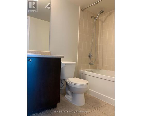 A white toilet sits next to a white sink in a bathroom.