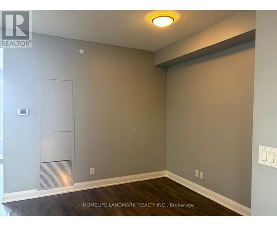 A room with a grey wall and a white door.
