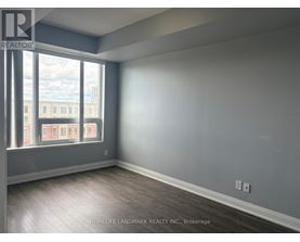 A room with a large window and wooden flooring.