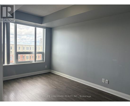 A room with a large window and wooden flooring.