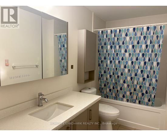 A bathroom with a sink, toilet, and shower curtain.