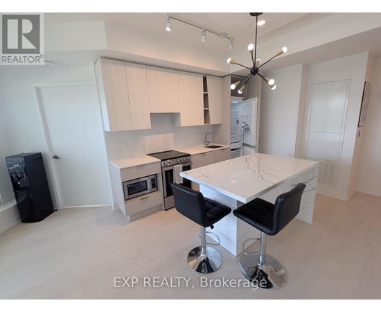 A modern kitchen with a large island and a dining area.