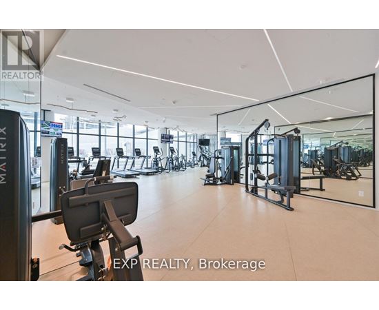 A gym with a mirrored wall and various exercise equipment.