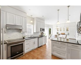 A modern kitchen with white cabinets and a stainless steel oven.