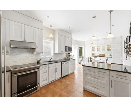 A modern kitchen with white cabinets and a stainless steel oven.