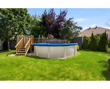 A small above ground pool with a wooden staircase.