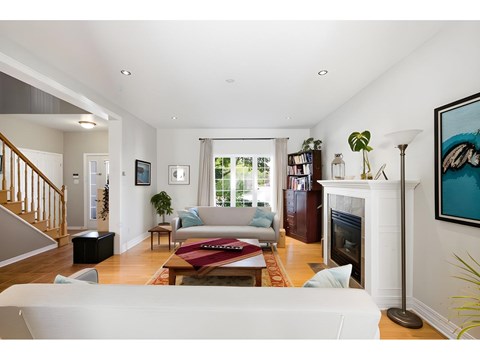 A living room with a fireplace and a painting on the wall.