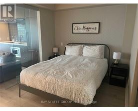 A bedroom with a bed, nightstand, and lamp.