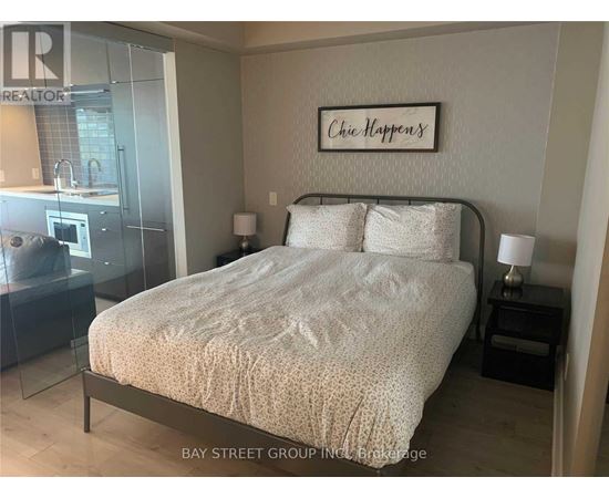 A bedroom with a bed, nightstand, and lamp.