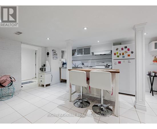 A white kitchen with a table and chairs.