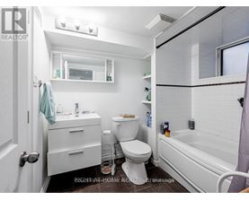 A white bathroom with a toilet, sink, and bathtub.