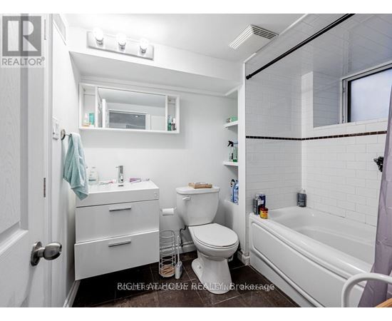 A white bathroom with a toilet, sink, and bathtub.