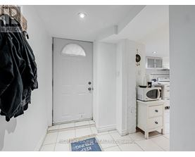 A white door is in a hallway with a sign on the floor.