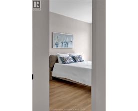 A bedroom with a bed and a painting on the wall.