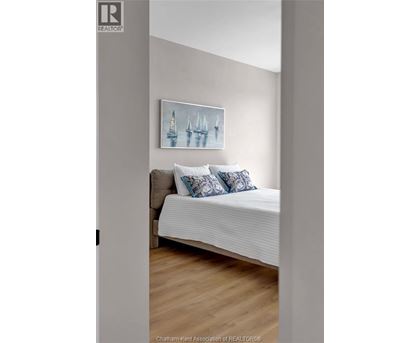 A bedroom with a bed and a painting on the wall.
