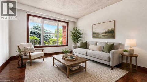 A living room with a couch, chair, and a table with a lamp on it.