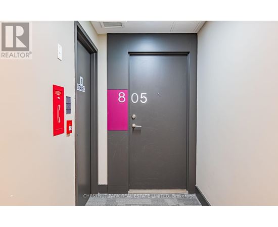 A black door with a pink sign that says 805.