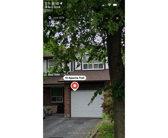 A house with a garage and a tree in front of it.