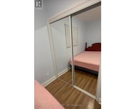 A bedroom with a pink bed and a mirror on the wall.