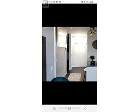 A modern interior with a white door and a round mirror on the wall.