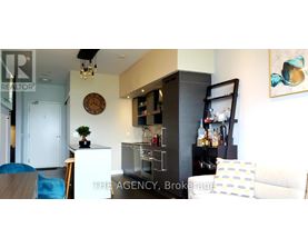 A living room with a couch, a chair, a cabinet, and a clock on the wall.