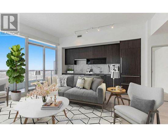 A modern living room with a grey sofa, a white coffee table, and a large window overlooking the city.