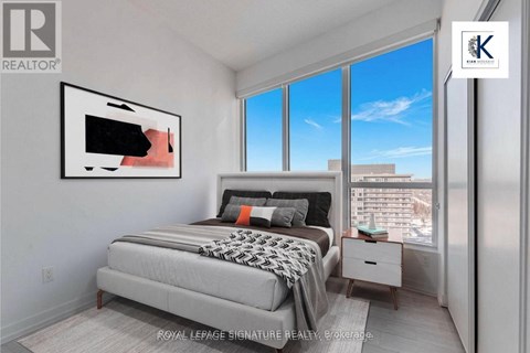 A bedroom with a large bed and a painting on the wall.
