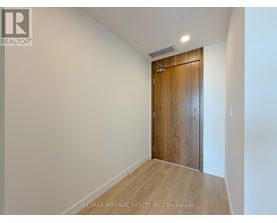 A room with a wooden door and a white wall.
