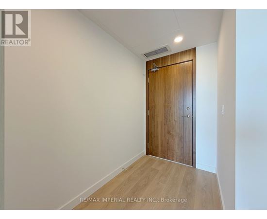 A room with a wooden door and a white wall.