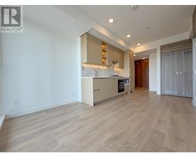 A spacious kitchen with wooden flooring and modern appliances.